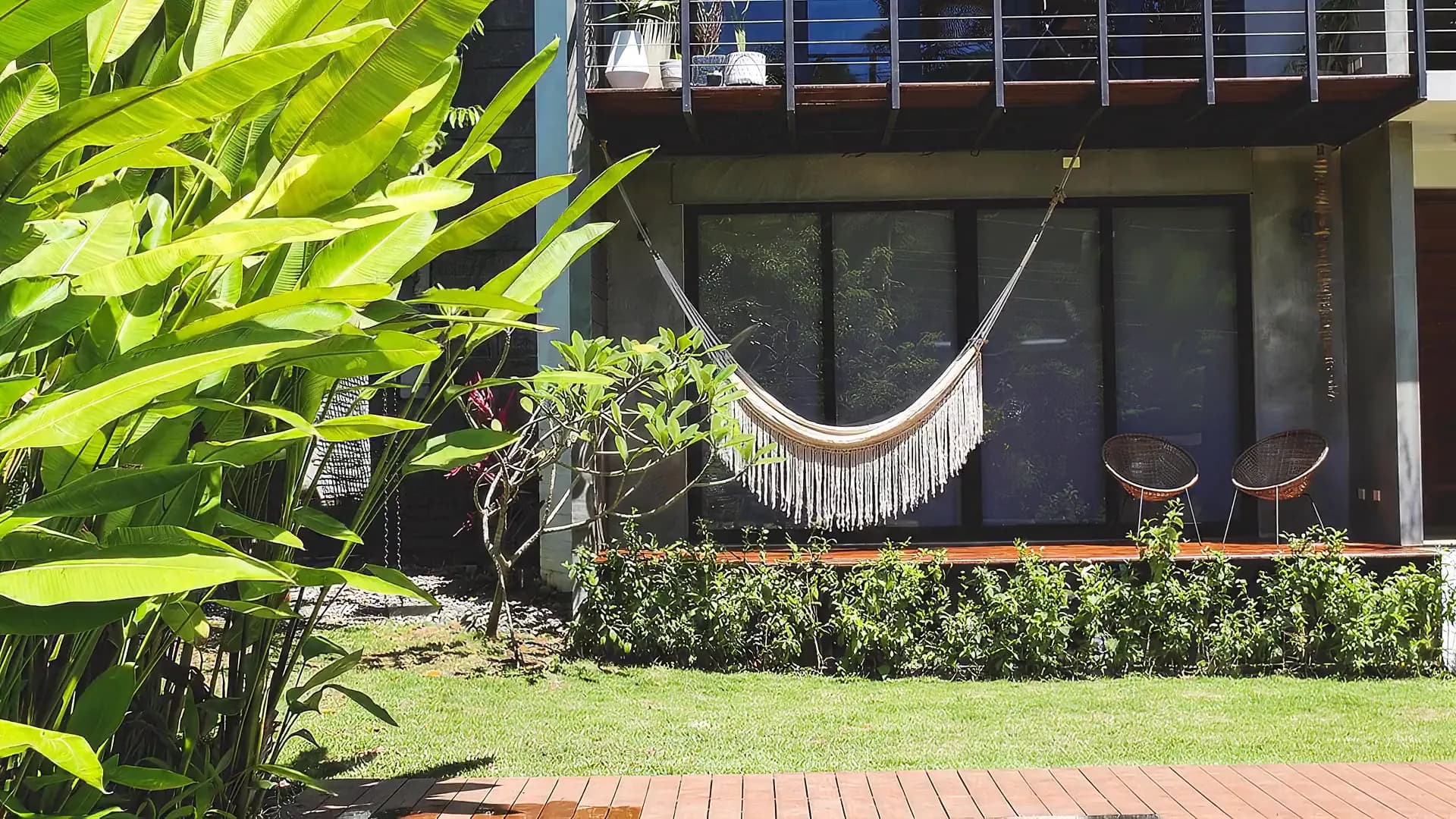 A Kooi hammock swaying on a garden porch